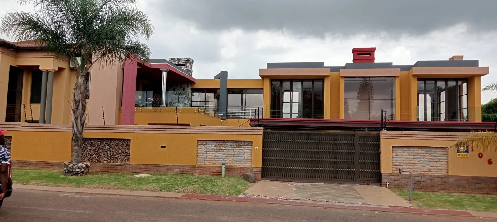 Modern home with large aluminium windows, glass balustrades and an aluminium sliding gate