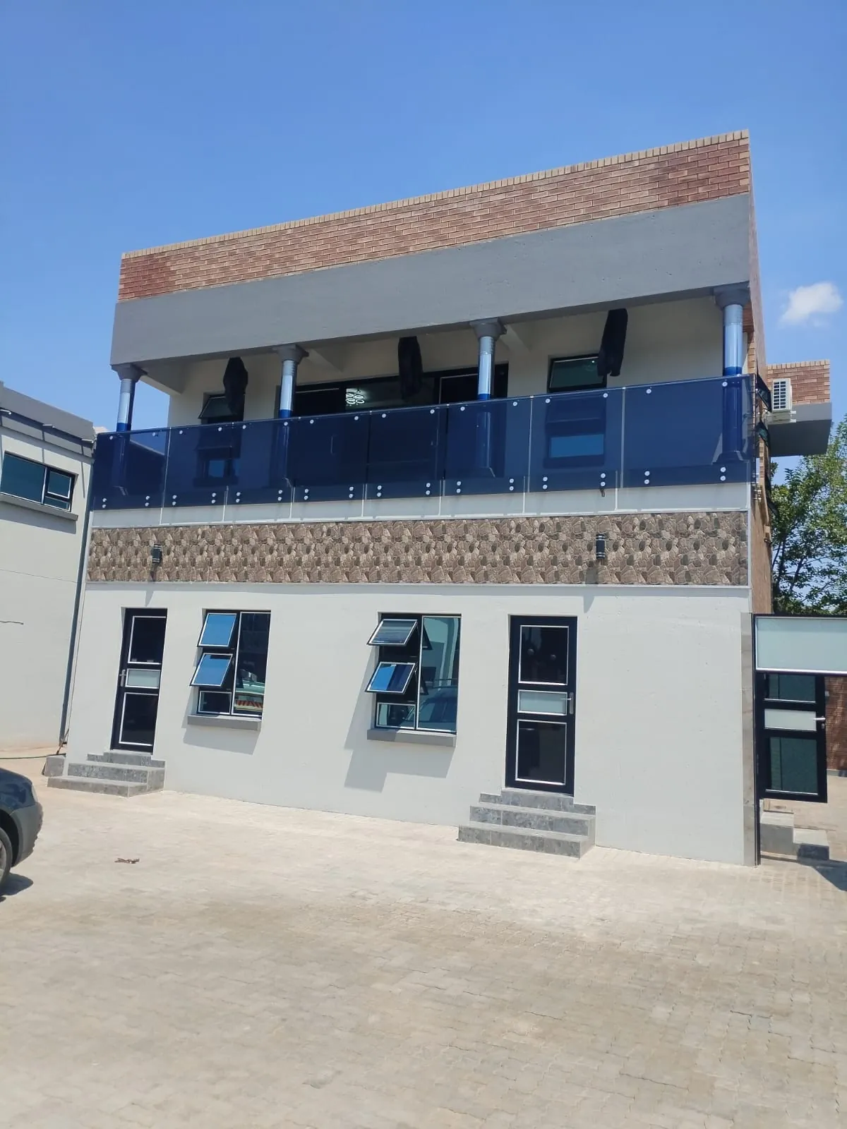 Commercial building with a tinted glass balcony balustrade, stainless steel columns and aluminium windows and doors