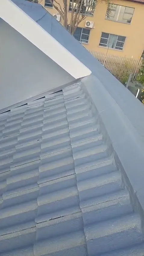 Close-up of freshly painted grey concrete roof tiles and ridge capping